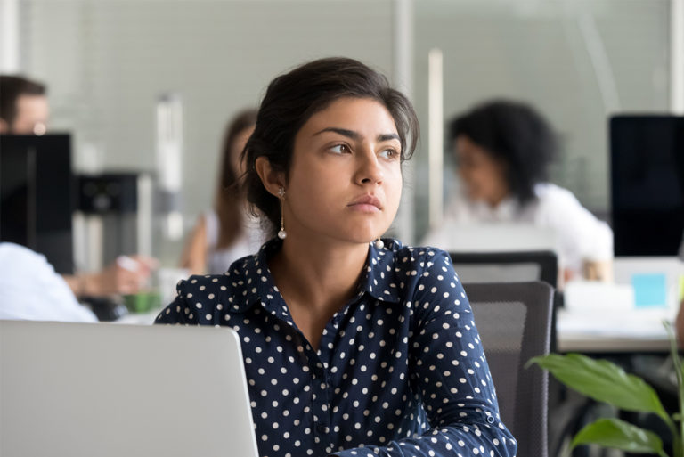 Thoughtful indian businesswoman looking away thinking of problem solution